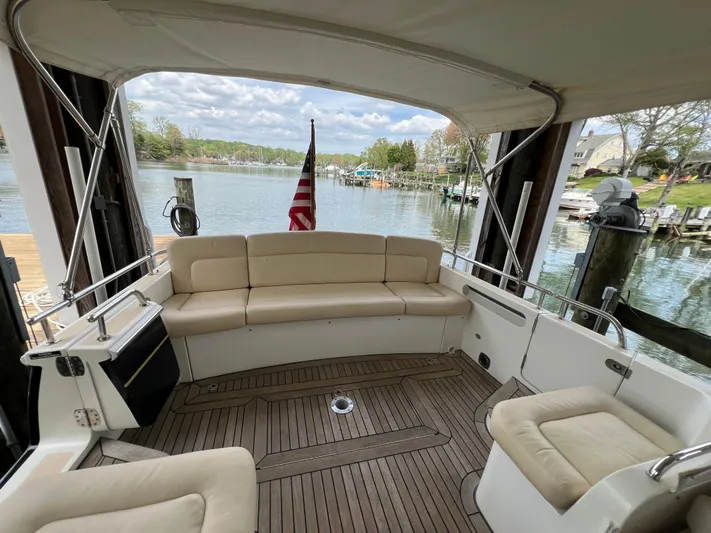 True Grace Yacht Photos Pics MJM 36Z 2011 boat interior with beige seating, wooden deck, and scenic waterfront view.