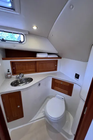 True Grace Yacht Photos Pics 2011 MJM 36Z boat bathroom with sink, toilet, and wooden cabinets.