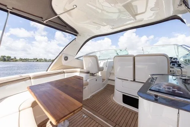 Pura Vida Yacht Photos Pics Luxurious 2012 Sea Ray 370 Sundancer yacht interior with seating and wooden table.