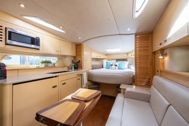 Pura Vida Yacht Photos Pics Luxurious interior of 2012 Sea Ray 370 Sundancer yacht with modern kitchen and cozy bedroom.