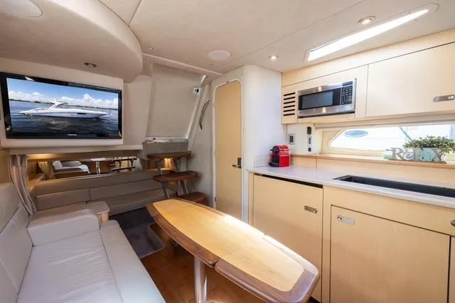 Pura Vida Yacht Photos Pics Interior of 2012 Sea Ray 370 Sundancer yacht with modern kitchen and seating area.