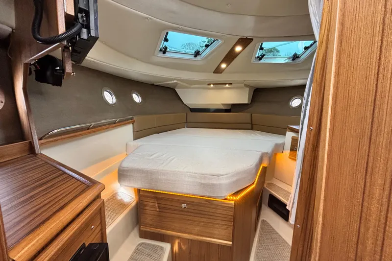  Yacht Photos Pics 2026 Ranger Tugs R-29 CB cabin interior with cozy bed and wooden accents.
