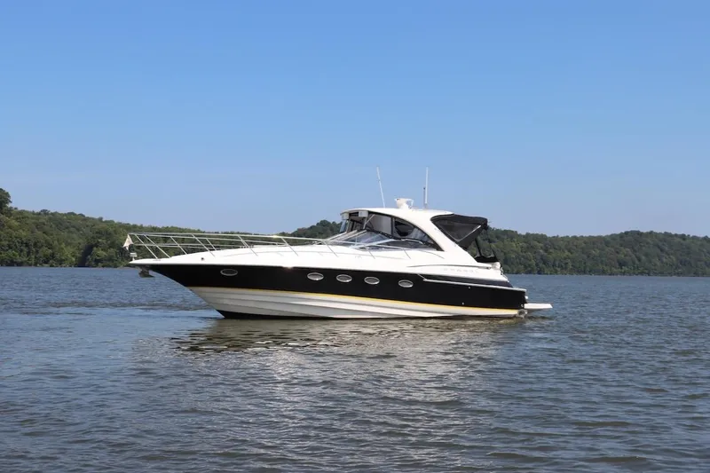 Cool Change Yacht Photos Pics 2006 Regal Commodore 4460 yacht cruising on a serene lake with forested shoreline.