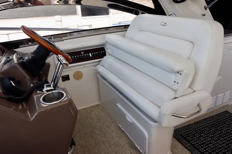 Cool Change Yacht Photos Pics 2006 Regal Commodore 4460 helm with white leather seat and wooden steering wheel.