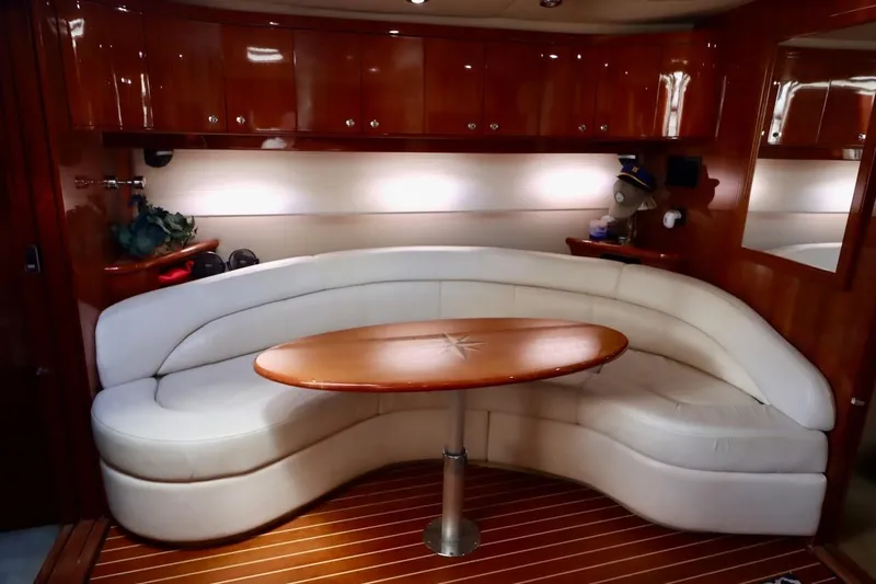 Cool Change Yacht Photos Pics Luxurious 2006 Regal Commodore 4460 yacht interior with curved seating and wooden table.