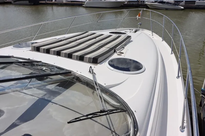 Cool Change Yacht Photos Pics 2006 Regal Commodore 4460 yacht with striped sun pad, docked in marina.