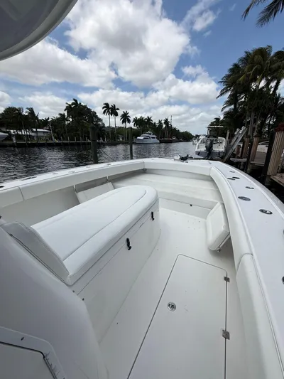 Miss Mae Yacht Photos Pics Freeman 2014 boat on a calm waterway, surrounded by palm trees and cloudy sky.