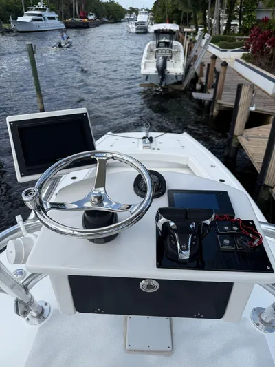 Miss Mae Yacht Photos Pics Boat steering console on a Freeman 2014 model, docked by a scenic waterway.