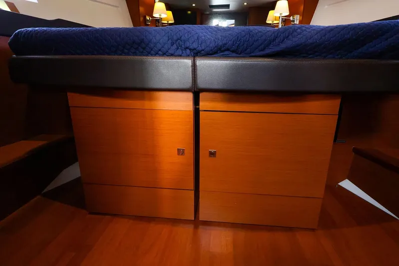 Tequila Little Time II Yacht Photos Pics Luxurious interior of 2015 Jeanneau NC 14 yacht with wooden cabinetry and blue bedding.