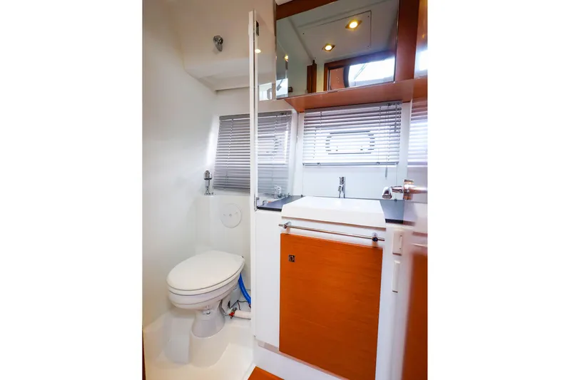 Tequila Little Time II Yacht Photos Pics 2015 Jeanneau NC 14 yacht bathroom with modern fixtures and wooden cabinetry.