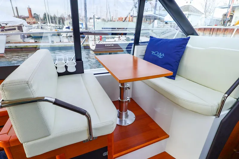 Tequila Little Time II Yacht Photos Pics Interior of 2015 Jeanneau NC 14 yacht with cozy seating and wooden table.