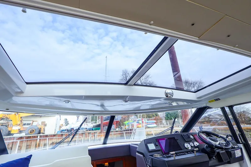 Tequila Little Time II Yacht Photos Pics Interior view of 2015 Jeanneau NC 14 yacht with panoramic sunroof and modern helm.