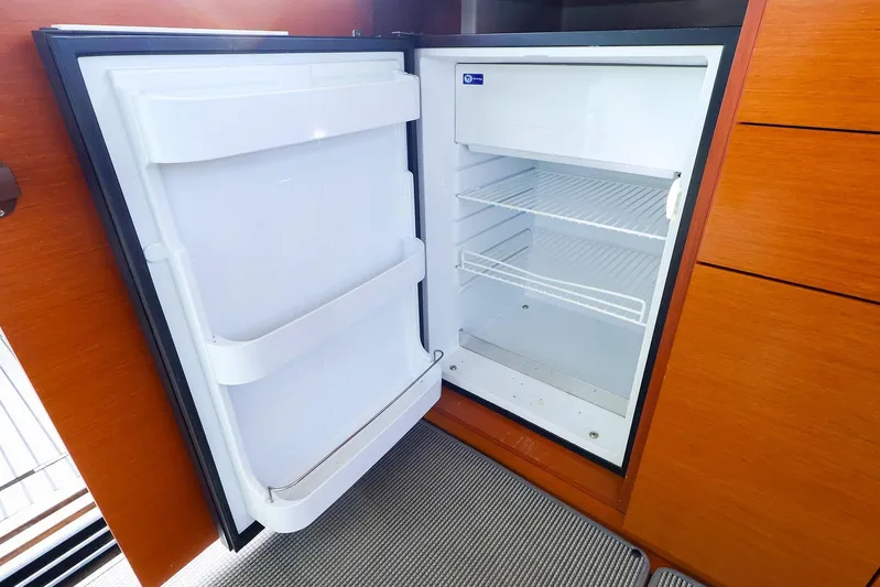 Tequila Little Time II Yacht Photos Pics Open refrigerator inside 2015 Jeanneau NC 14 yacht, showcasing interior shelves.