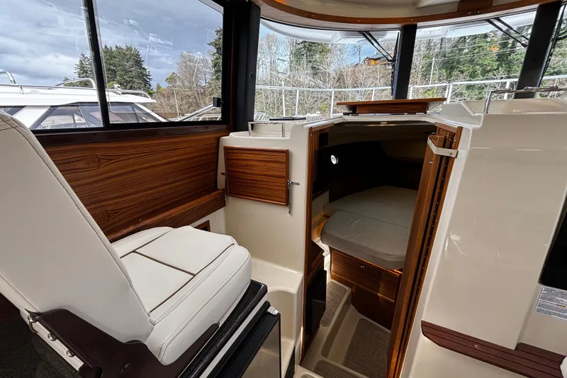  Yacht Photos Pics 2026 Ranger Tugs R-29 CB interior with helm seat and cabin entrance.