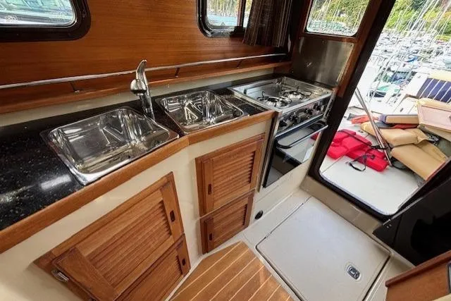 Fish Tank Yacht Photos Pics 2013 Ranger Tugs R-31 galley with dual sinks, stove, and wooden cabinetry.