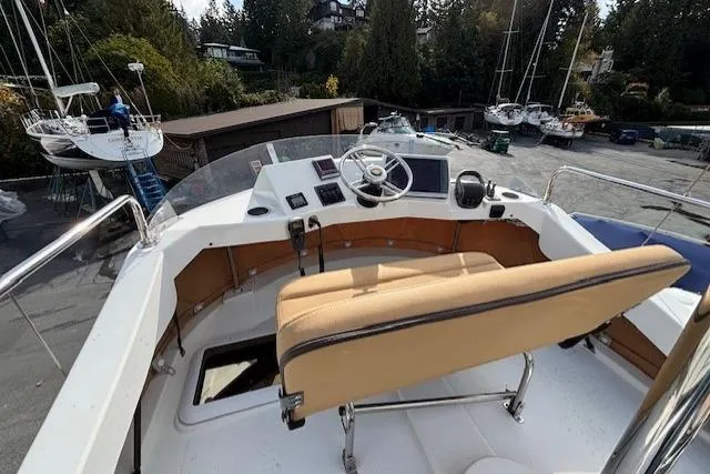 Fish Tank Yacht Photos Pics 2013 Ranger Tugs R-31 boat helm with beige seating, docked in a marina.