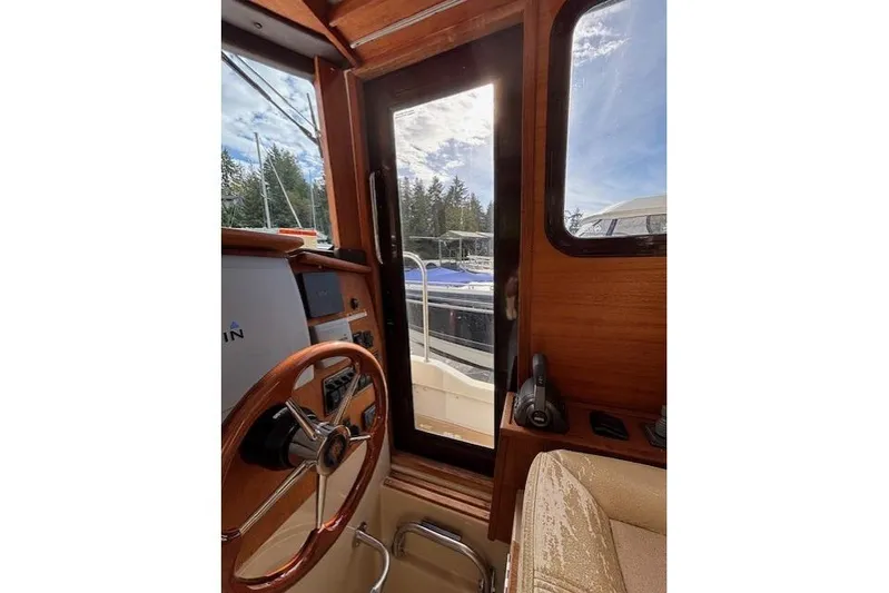Fish Tank Yacht Photos Pics Interior view of 2013 Ranger Tugs R-31 boat cockpit with steering wheel and window.