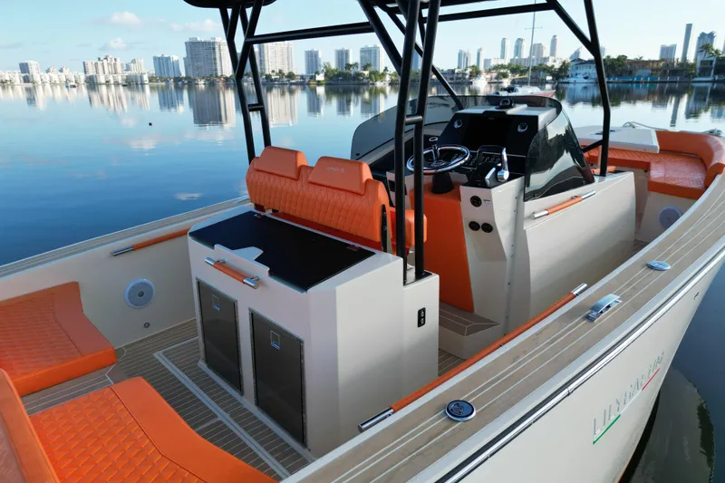  Yacht Photos Pics 2026 Lilybaeum Lipari 31 boat interior with orange seating, modern controls, and city skyline backdrop.
