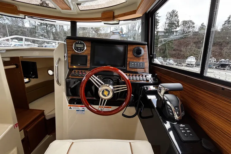  Yacht Photos Pics Interior cockpit of 2026 Ranger Tugs R-25 with wooden steering wheel and control panel.
