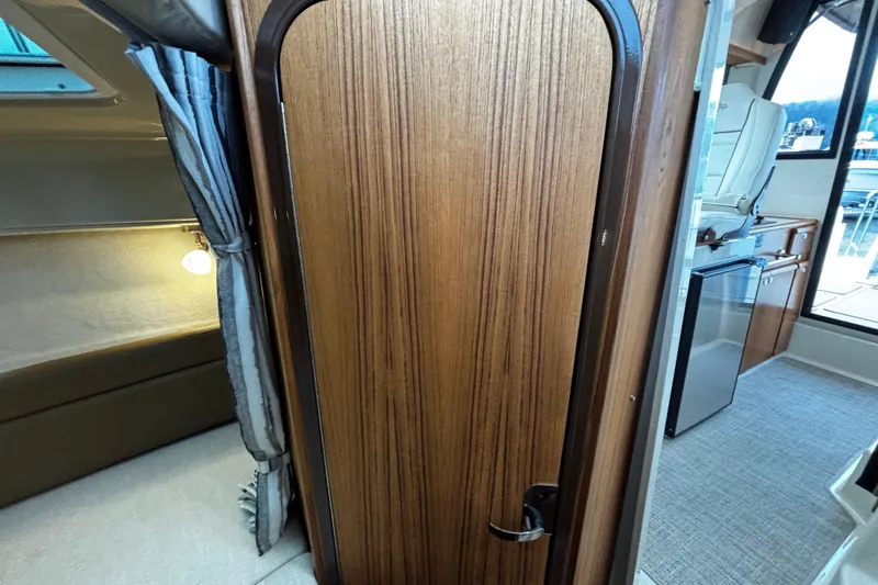  Yacht Photos Pics 2026 Ranger Tugs R-25 interior with wood door, cozy cabin, and kitchenette.