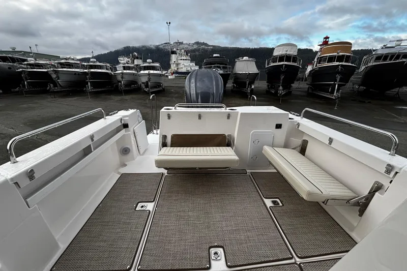  Yacht Photos Pics 2026 Ranger Tugs R-25 boat interior with foldable seating, docked among other boats.