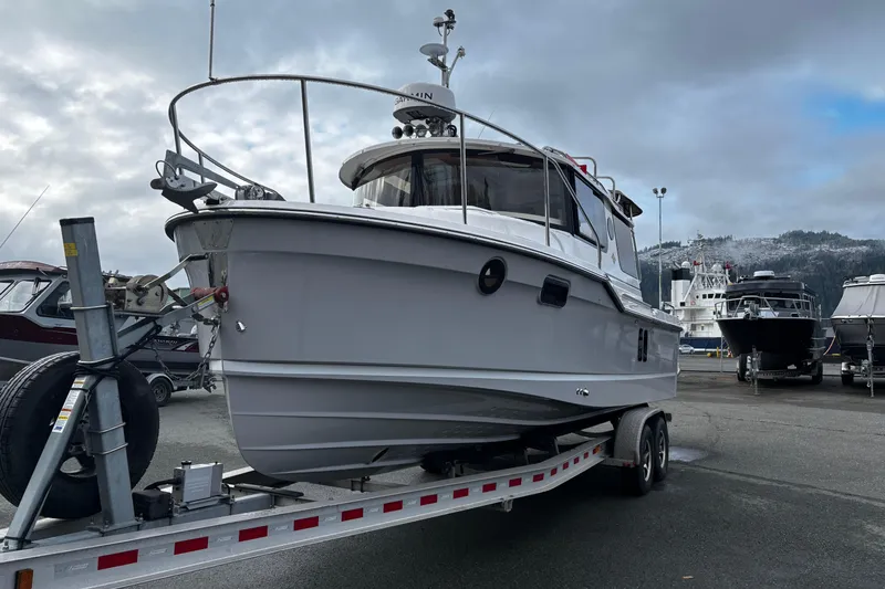  Yacht Photos Pics 2026 Ranger Tugs R-25 boat on trailer, parked in marina with cloudy sky.