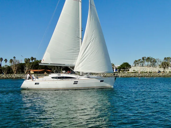 In Stock Now Yacht Photos Pics 2018 Elan 45 Impressions sailboat cruising on calm waters under clear blue skies.