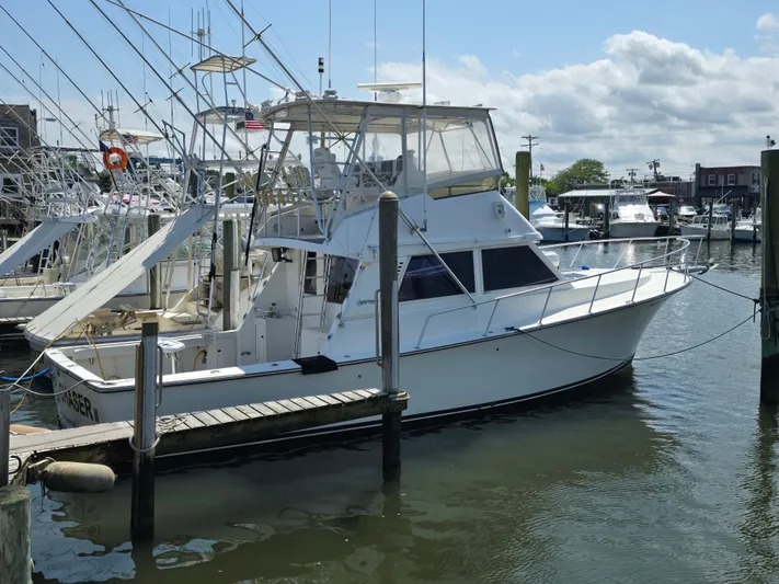  Yacht Photos Pics 1998 Henriques 38 Sportfisherman docked at a marina under a partly cloudy sky.