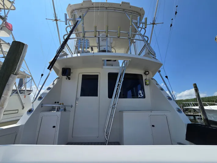  Yacht Photos Pics 1998 Henriques 38 Sportfisherman boat with tower and fishing equipment under clear blue sky.