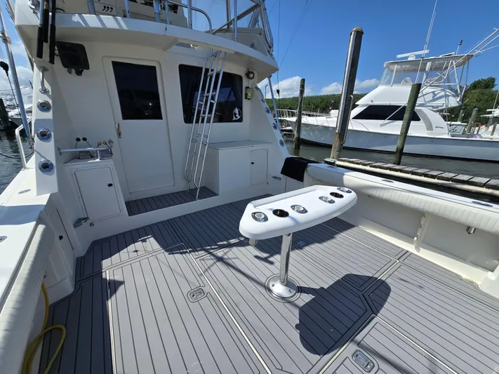  Yacht Photos Pics 1998 Henriques 38 Sportfisherman boat deck with fishing rod holders, docked at marina.