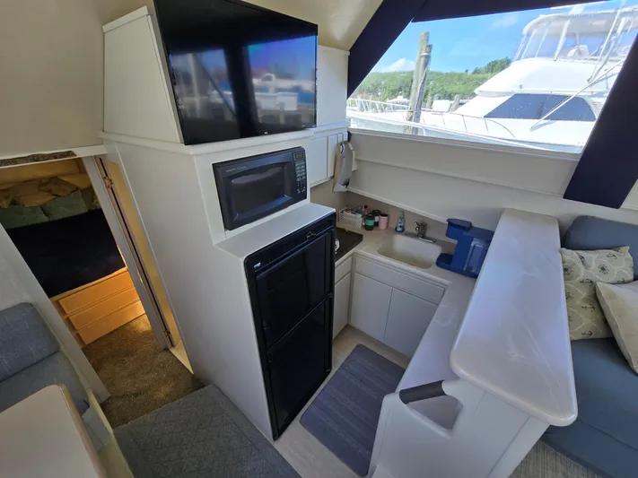  Yacht Photos Pics Interior of 1998 Henriques 38 Sportfisherman with kitchenette, microwave, and seating area.