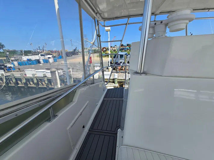  Yacht Photos Pics 1998 Henriques 38 Sportfisherman boat deck with marina view, featuring sleek design and sturdy railings.