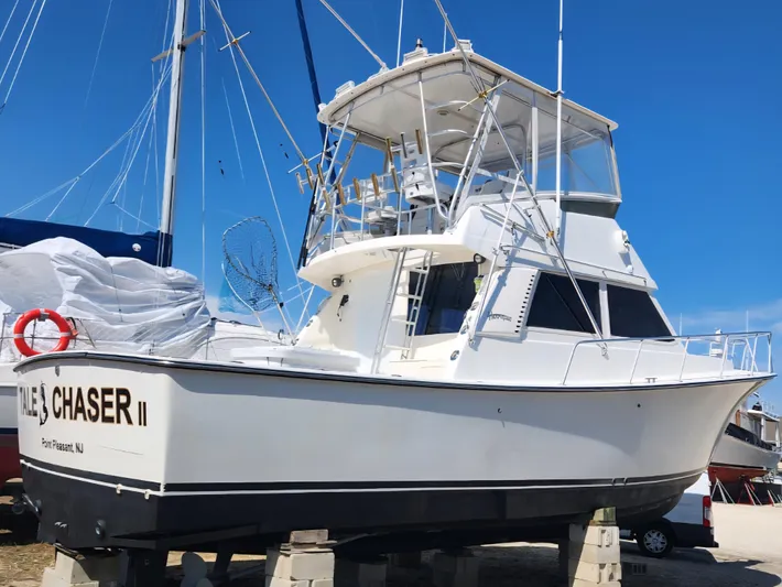  Yacht Photos Pics 1998 Henriques 38 Sportfisherman boat on blocks, clear sky background.
