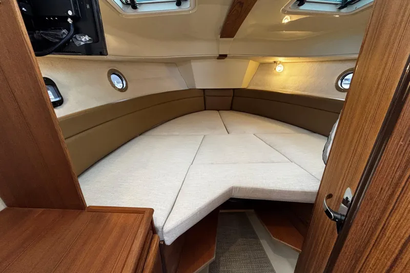  Yacht Photos Pics 2026 Ranger Tugs R-25 interior cabin with cozy sleeping area and wooden accents.