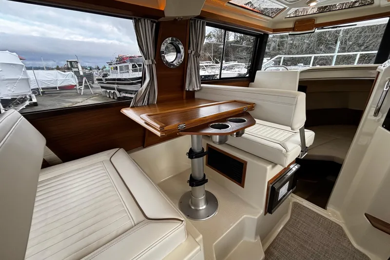  Yacht Photos Pics 2026 Ranger Tugs R-25 interior with elegant seating and wooden table.