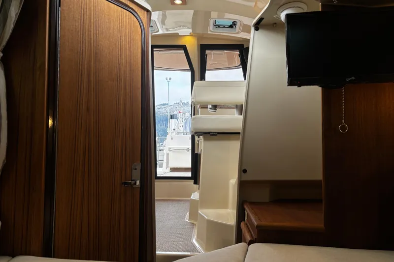  Yacht Photos Pics Interior view of 2026 Ranger Tugs R-25 boat, featuring wood paneling and a mounted TV.