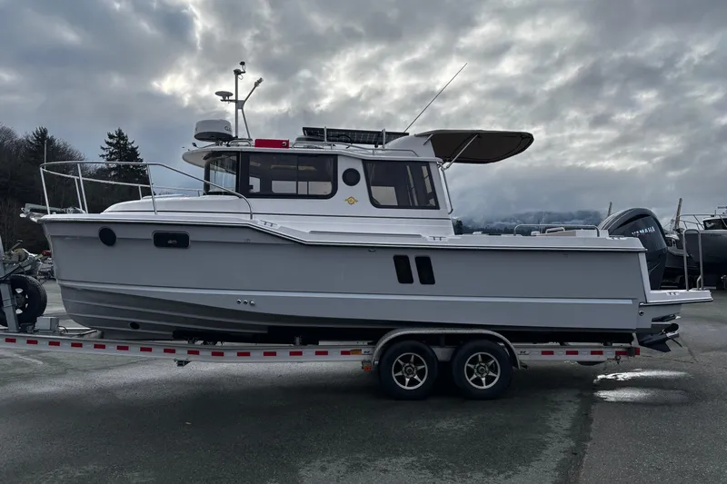  Yacht Photos Pics 2026 Ranger Tugs R-25 boat on trailer under cloudy sky.
