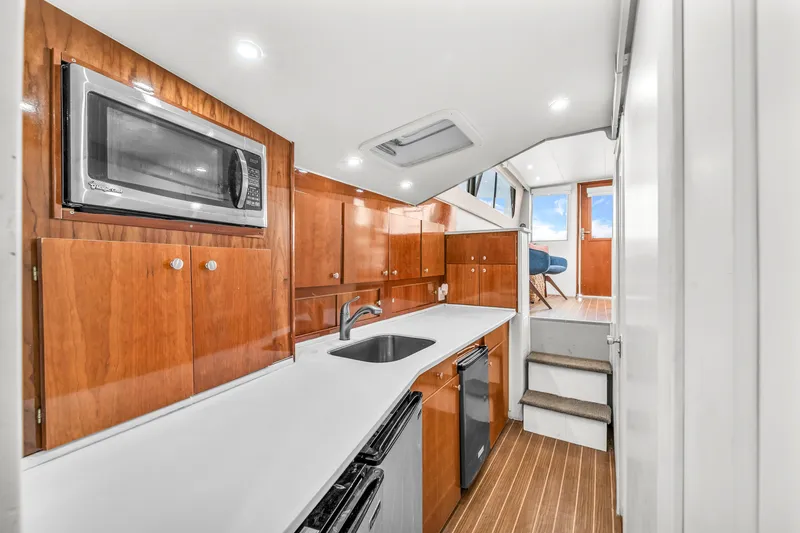  Yacht Photos Pics 1978 Hatteras 42 Convertible yacht interior with modern kitchen and wooden cabinetry.