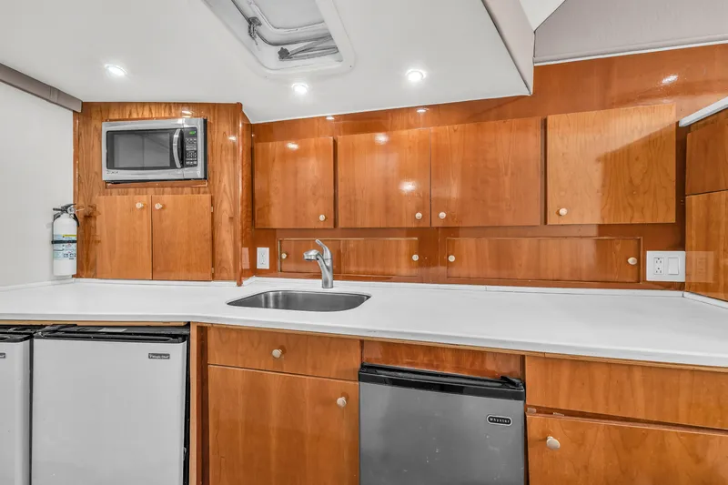  Yacht Photos Pics 1978 Hatteras 42 Convertible yacht kitchen with wooden cabinets, microwave, and sink.