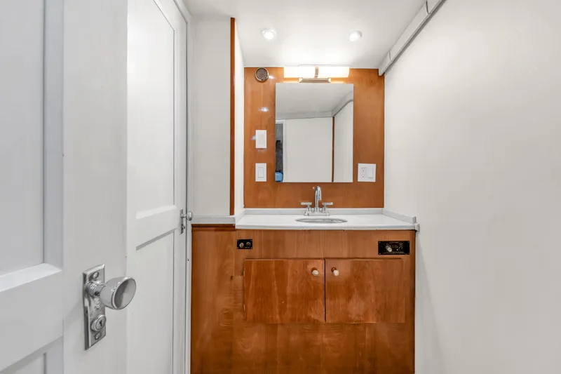  Yacht Photos Pics 1978 Hatteras 42 Convertible bathroom with wooden vanity, mirror, and modern fixtures.