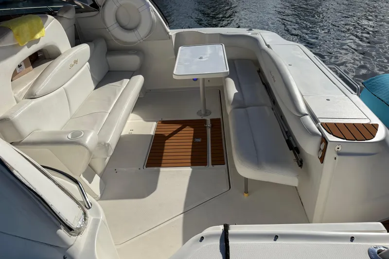  Yacht Photos Pics 1999 Sea Ray 410 Express Cruiser interior with white seating and table by the water.