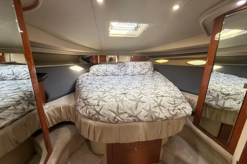  Yacht Photos Pics 1999 Sea Ray 410 Express Cruiser cabin with starfish-patterned bedding and mirrored walls.