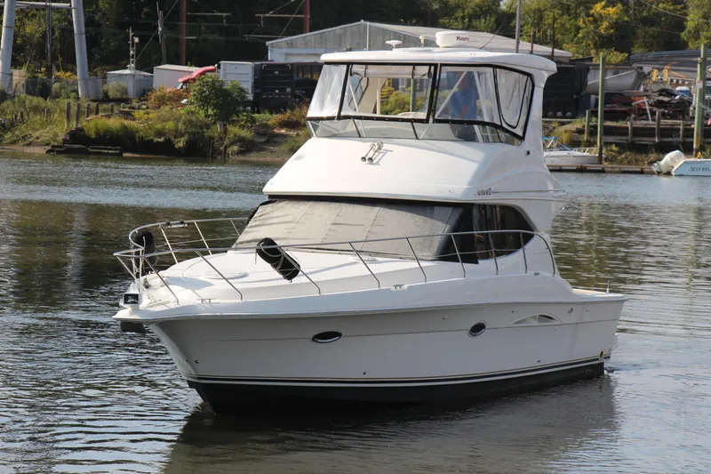  Yacht Photos Pics 2003 Silverton 38 Convertible yacht on calm water near a marina.