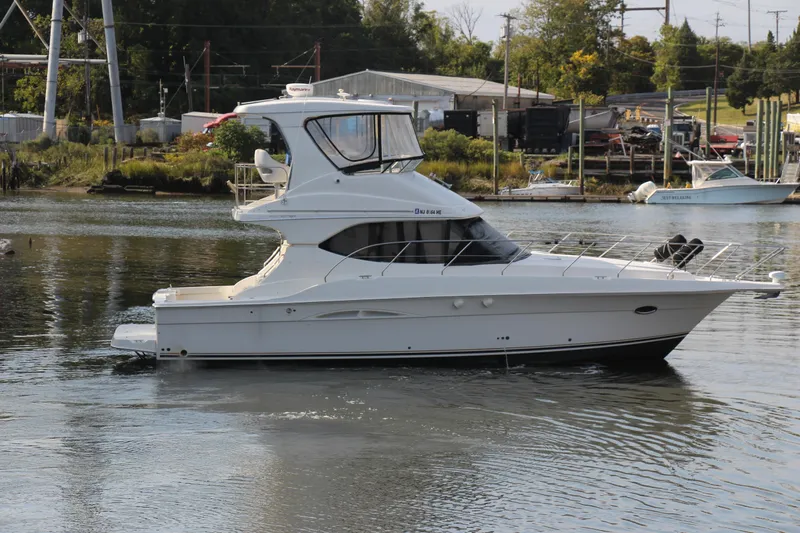 Yacht Photos Pics 2003 Silverton 38 Convertible yacht on calm water near a marina.