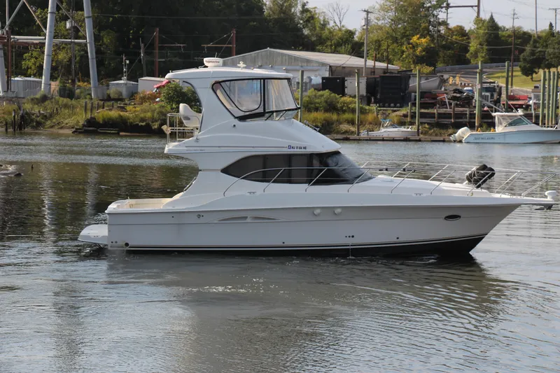  Yacht Photos Pics 2003 Silverton 38 Convertible yacht on calm water near a marina.