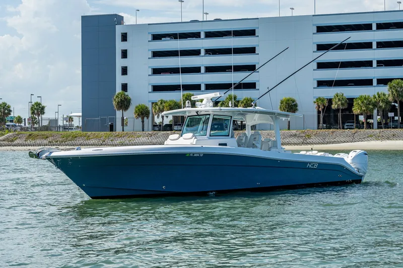 Tingum Yacht Photos Pics 2021 HCB 42 Lujo boat on water near a modern building.