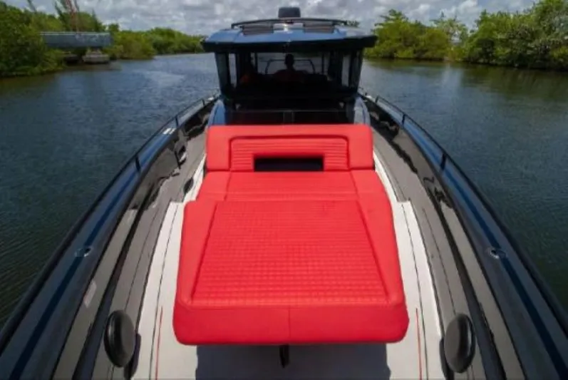  Yacht Photos Pics 2021 BRABUS Shadow 900 BO with red sunbed on deck, cruising through a serene waterway.