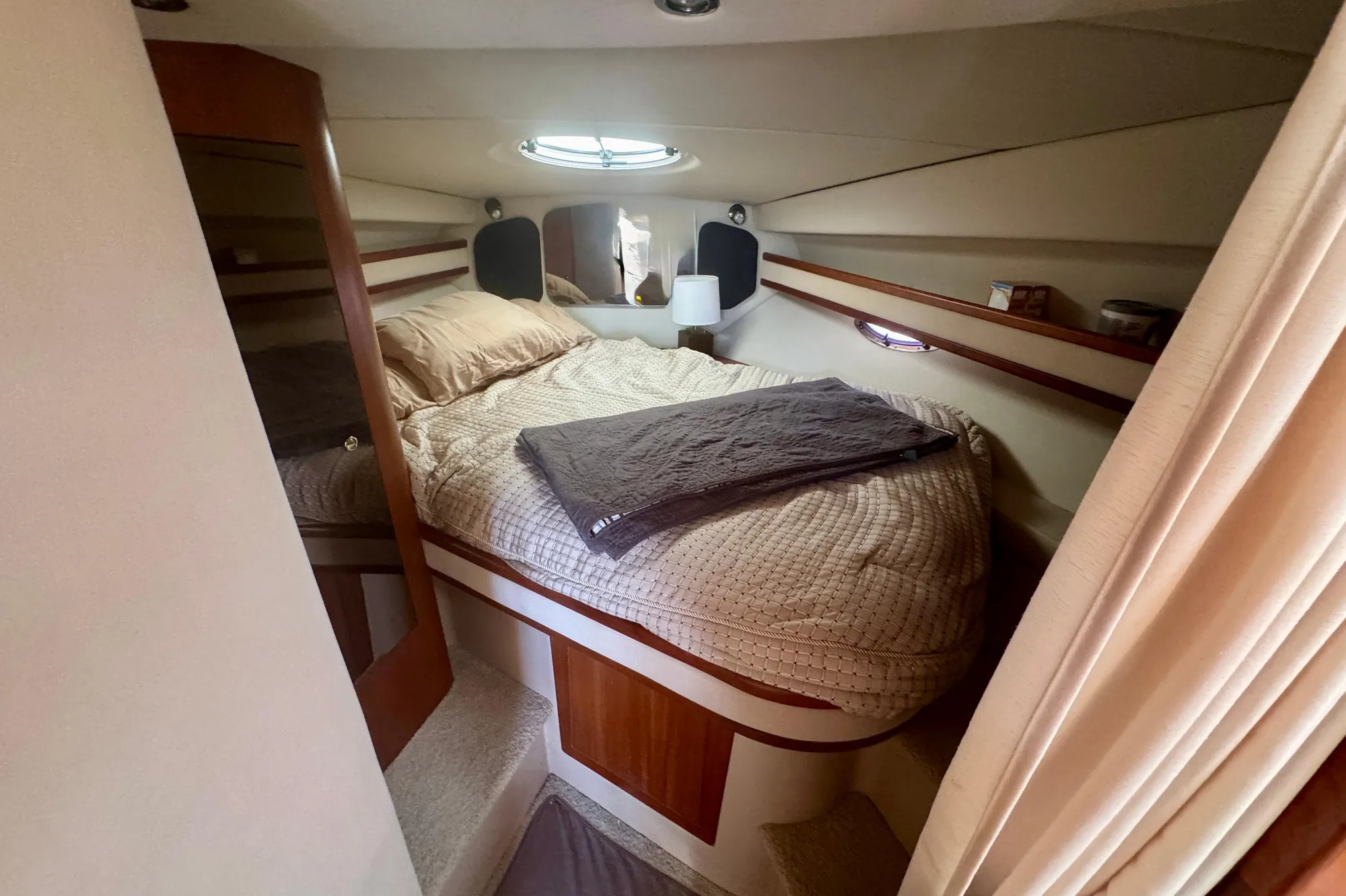 Cozy cabin interior of 2001 Cruisers Yachts 3470 Express with bed and porthole.