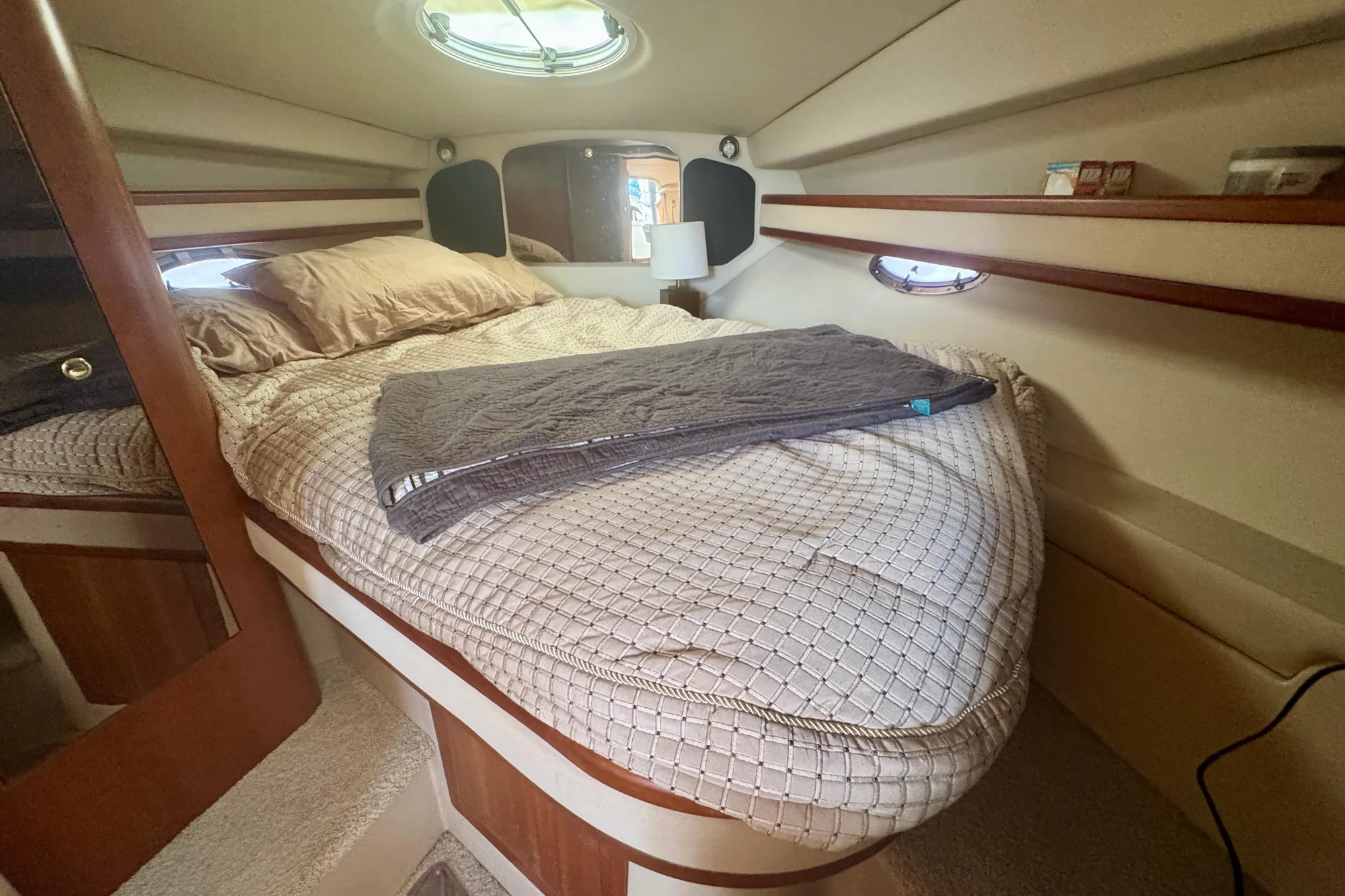Cozy cabin interior of 2001 Cruisers Yachts 3470 Express with bed and porthole.