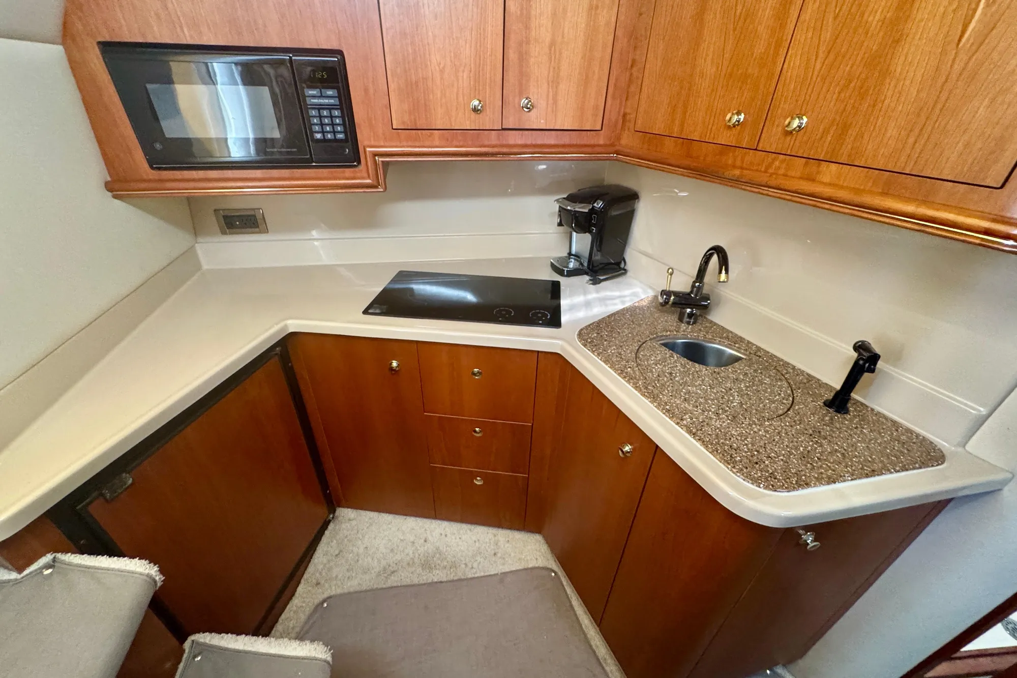 2001 Cruisers Yachts 3470 Express galley with microwave, stovetop, and sink.